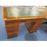 A modern yew finished nine drawer twin pedestal desk
