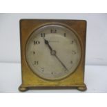 An early 20th century brass cased travelling bedside alarm clock. The dial having Arabic numerals