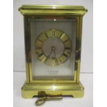 A brass cased four glass, three train mantle clock striking on eight rods. The silvered dial