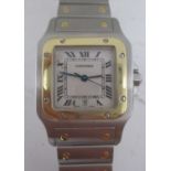 A Cartier Santos gents, stainless steel and gold quartz wristwatch, model 1566. The square dial with