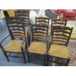 A set of six oak ladder back, rush seated dining chairs, two being carvers