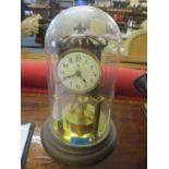 An early 20th century brass anniversary clock with a glass dome