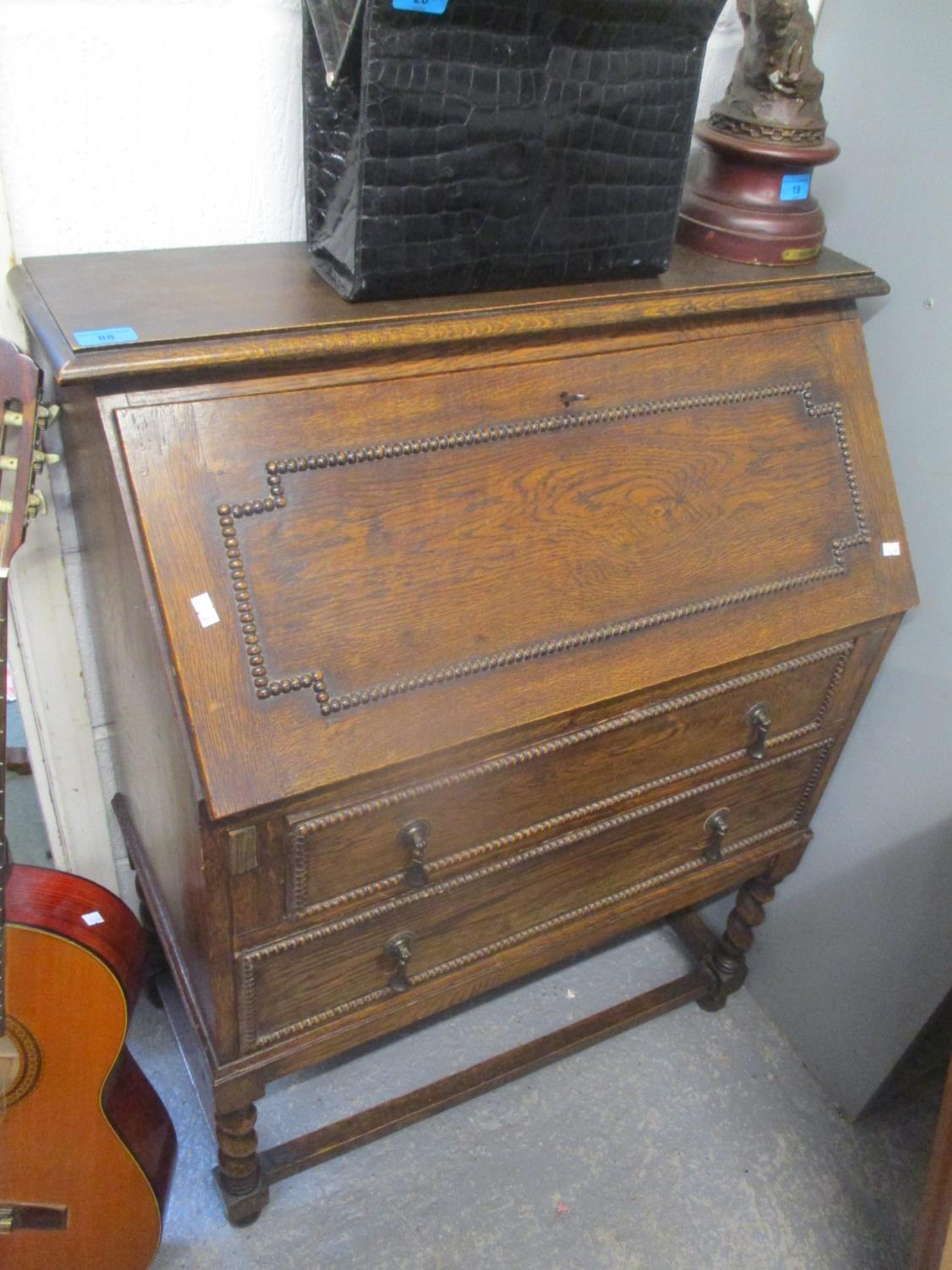 A 1930s oak bureau, 39 1/2"h x 30 1/4"w and two spindle back elm seated chairs