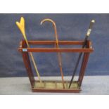 A mahogany umbrella/stick stand with four drip trays, a vintage sword stick and another of unknown