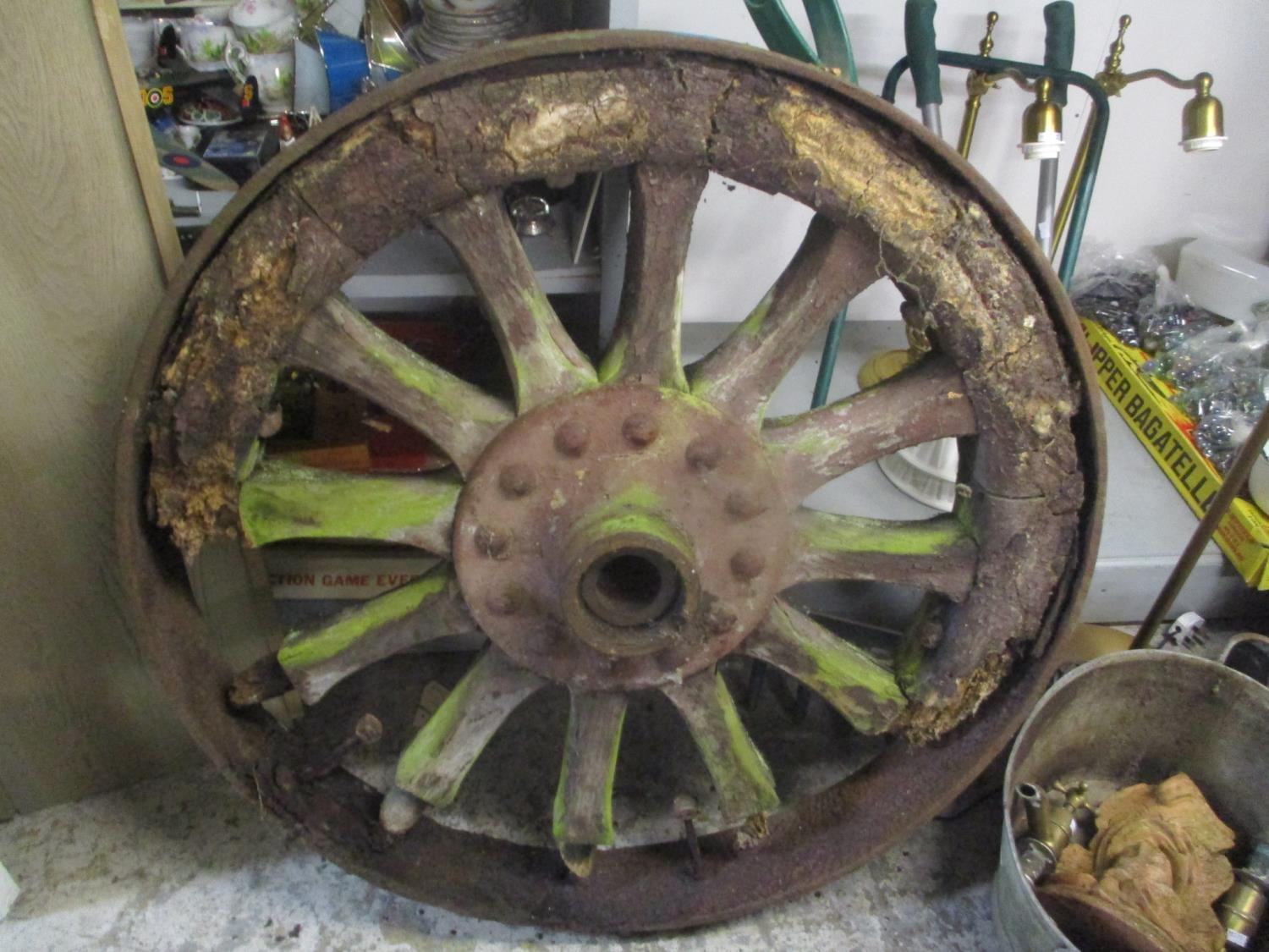 A large weathered cart wheel having a cast iron frame, 38" dia