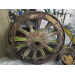 A large weathered cart wheel having a cast iron frame, 38" dia