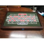 A gaming box with roulette wheel, counters and other items