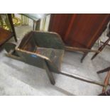 An early 20th century green painted and polished pine child's wheelbarrow