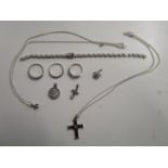 A group of silver set and diamond pendants, silver and diamond set rings, a silver cross set with