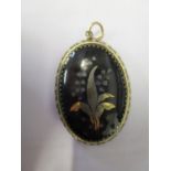 A Victorian plaque mourning pendant inlaid in gold and silver metal to the front, the back with