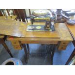 An early 20th century oak Singer sewing machine table with inset sewing machine