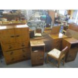 An Art Deco burr walnut veneered bedroom suite consisting of a dressing table, chest of drawers,