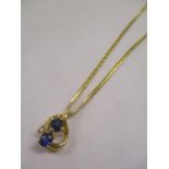 A gold coloured metal necklace and pendant set with diamonds and sapphires