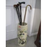 A stick stand with assorted sticks, possibly Chinese