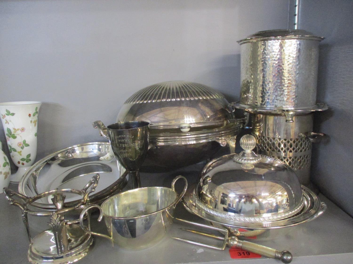 A quantity of silver plated items to include a trophy, a wine holder, and a Walker and Hall ice