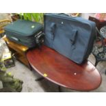 A mixed lot to include a mahogany oval coffee table, teak table, two suitcase and globe trotter bags