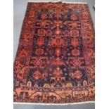 An Iranian red and blue ground rug having multiguard borders and geometric designs 82" x 57"