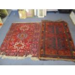 Two Middle Eastern red ground rugs having multiguard borders and tasselled ends