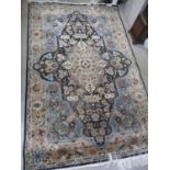 A Middle Eastern blue ground rug having a floral design and tasselled ends