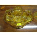 A 1930s golden amber press glass dressing table set, decorated with butterflies and flower heads