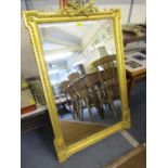 A 20th century gilt wall mirror with crossed torch detail to the top