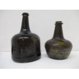 Two 17th/18th century brown/green glass wine bottles, one of a mallet design, 7 1/2"h and the