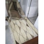Two Egyptian hand-made wool rugs in tones of brown and cream with geometric motifs