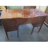 An Edwardian mahogany dressing/side table having a central door flanked by cupboard doors and