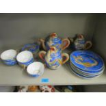 A Japanese early 20th century porcelain part tea set with dragon decoration, the cups with a