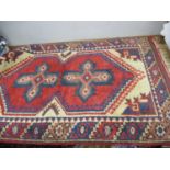 A Middle Eastern small hand woven rug, 49" x 29" with red ground and tassels