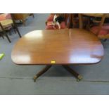 A reproduction Regency style pedestal coffee table on splayed legs with lion paw cups and castors,