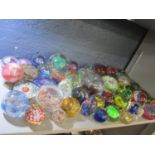 A large quantity of glass paperweights to include Caithness and others