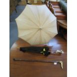 Two early 20th century parasols and an antler handled walking stick