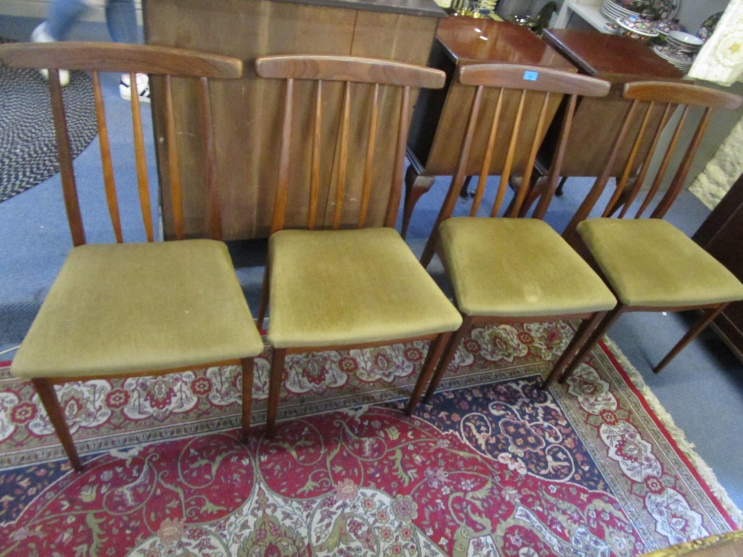 A set of four retro teak dining chairs with upholstered seats