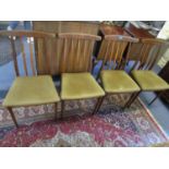A set of four retro teak dining chairs with upholstered seats