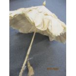 A late 19th/early 20th century parasol having a monogrammed and ivory handle and a cream silk canopy