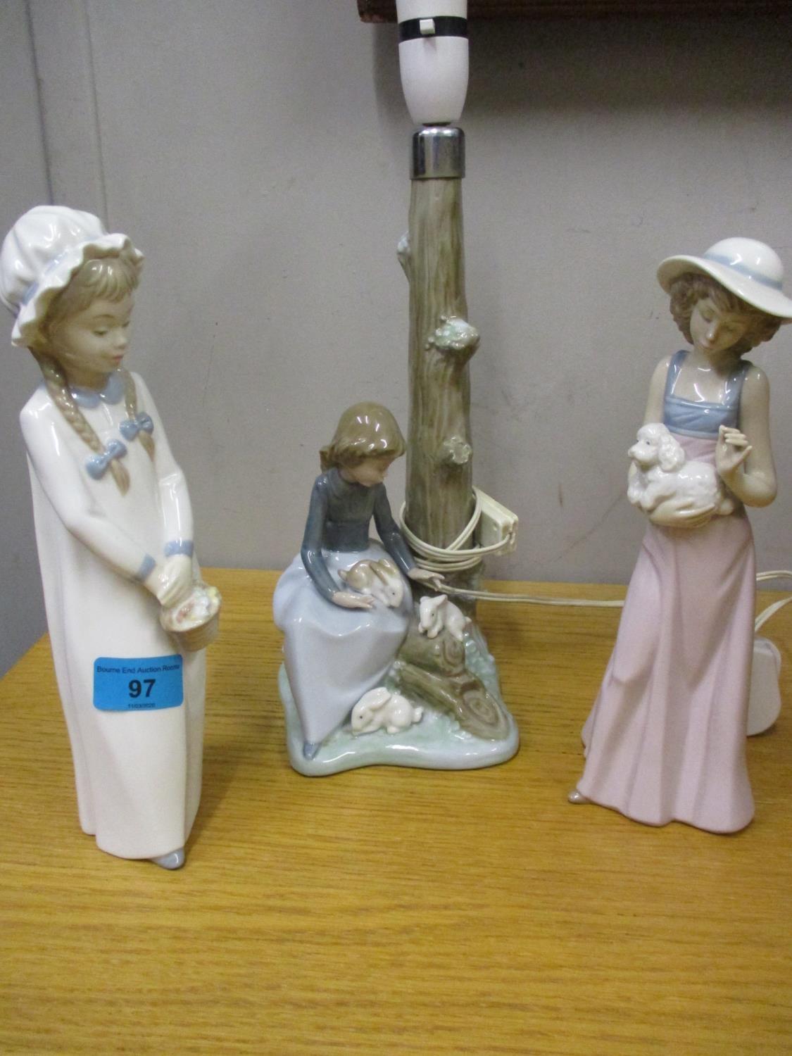 A Lladro figural table lamp, and two Nao figurines