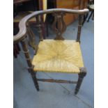An oak framed and lyre back corner chair with rattan seat