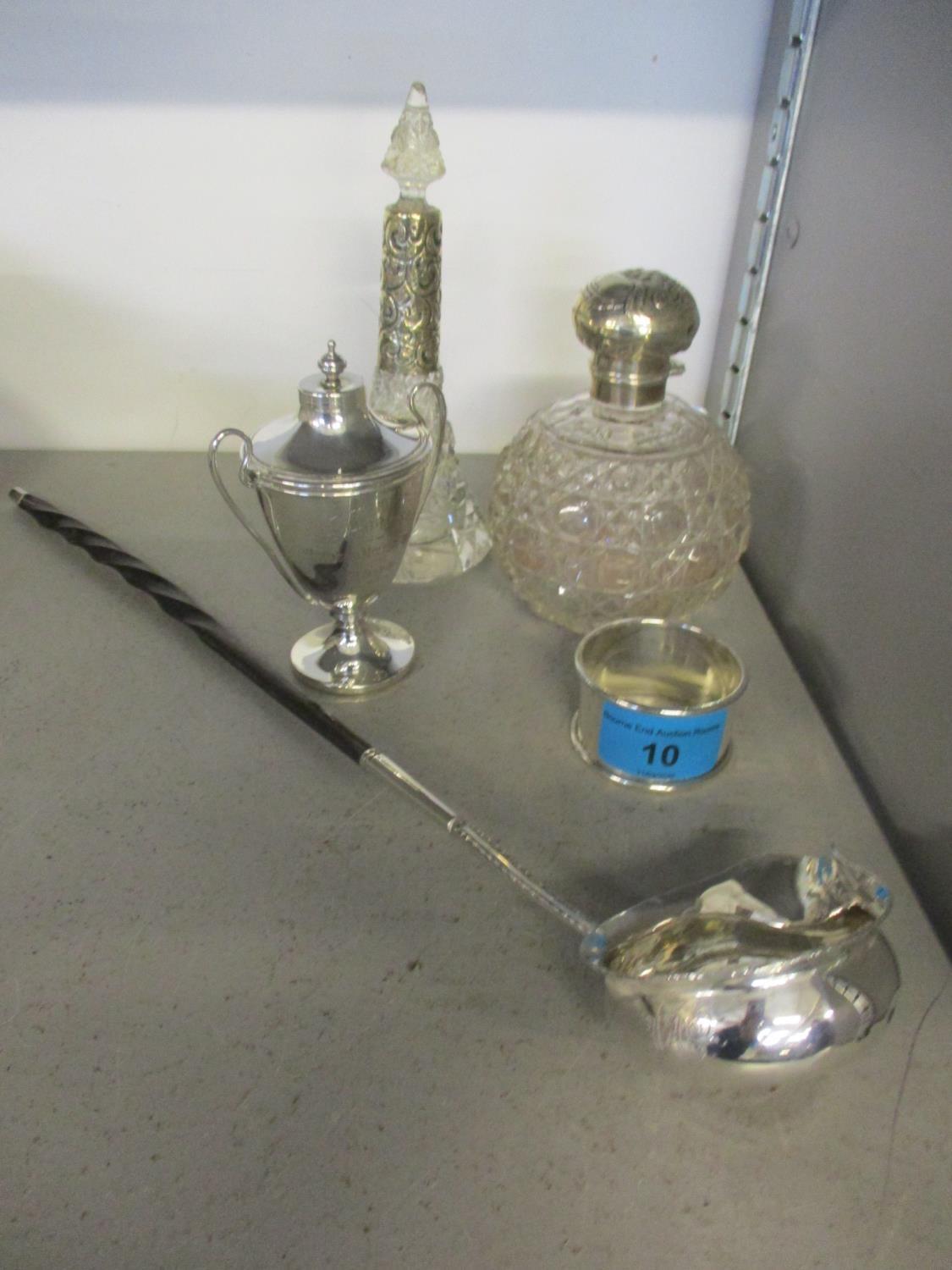 Two silver topped dressing table bottles, a silver trophy, a silver napkin ring and a white metal
