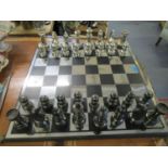 A large modern chess set, the board with metal top, in a brushed, silver coloured and matt black