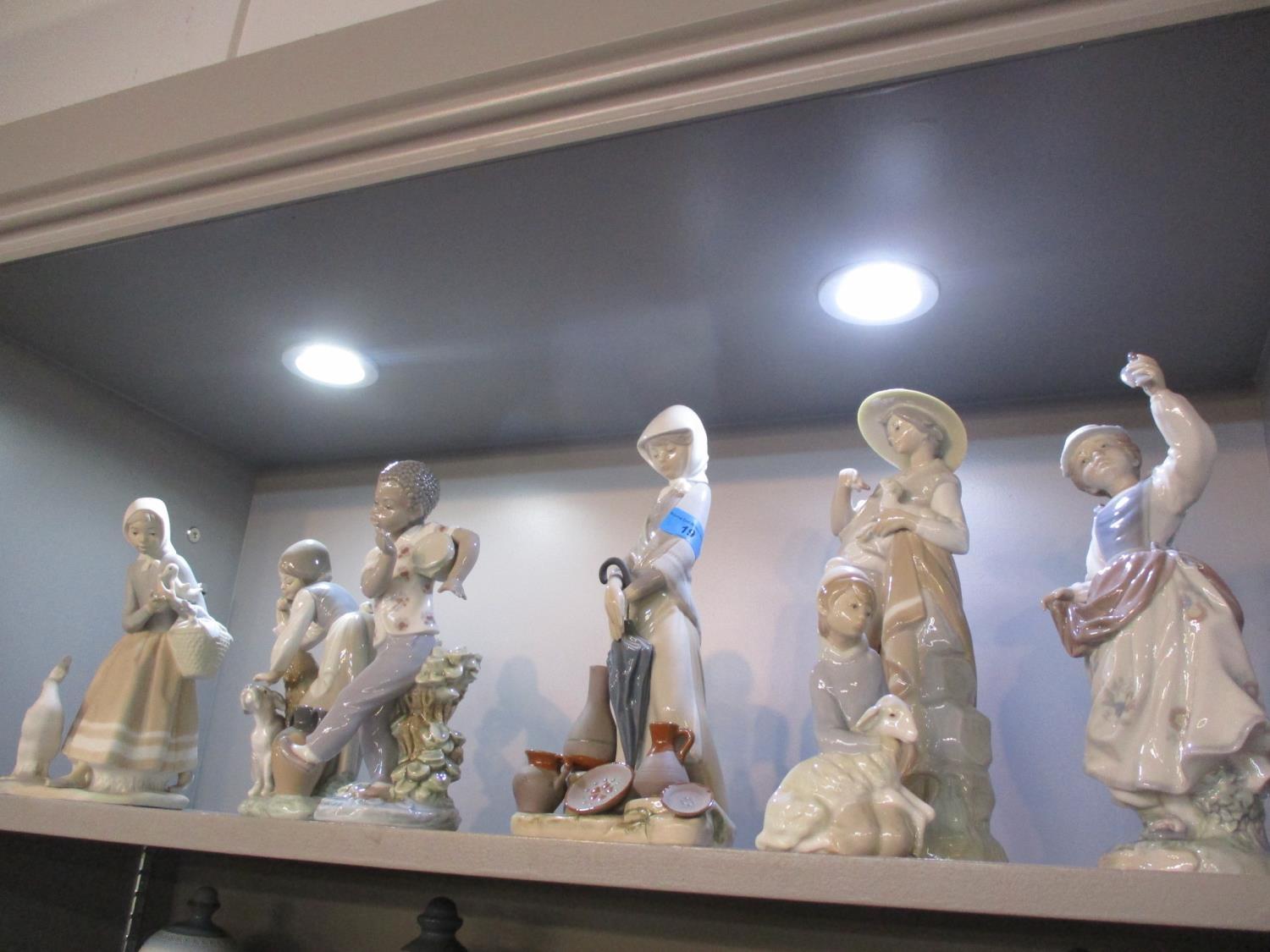 Seven Lladro figures to include a young boy playing a drum
