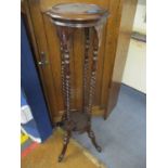 A reproduction mahogany torchere with barley twist supports