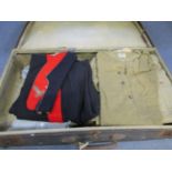 A vintage suitcase containing a Royal Artillery cap with matching trousers, various military