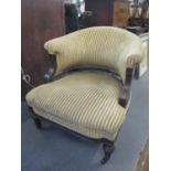 A Victorian mahogany horseshoe shaped salon armchair having short spindle backs and fluted front