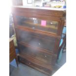 An early 20th century oak globe wernicke bookcase having acanthus leaf carved corners, dental