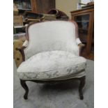 An early 20th century mahogany show framed upholstered armchair, floral carved crest rail,