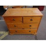 An early 20th century pine chest of two short and two long drawers