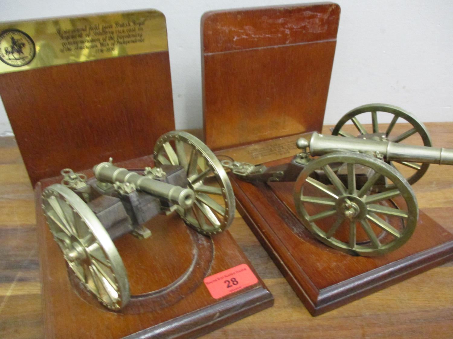 A pair of British American Bicentenary brass cannons, each on mahogany bookend stands