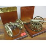 A pair of British American Bicentenary brass cannons, each on mahogany bookend stands