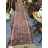 A Decorwool woollen runner, floral pattern in red and blue 290" x 35 3/4"